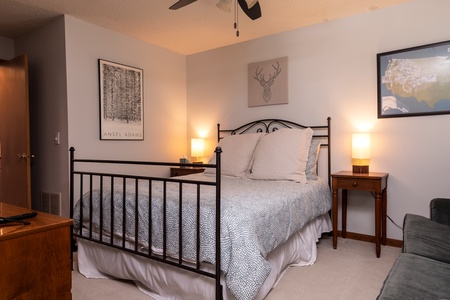 - Queen bedroom with iron frame bed soft linens and artwork - Warm bedside lamps create a peaceful inviting atmosphere - Comfortable setting for restful sleep during your Vermont stay