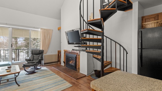 Spiral Stairs to Loft Bedroom living room with gas fireplace and TV with Roku