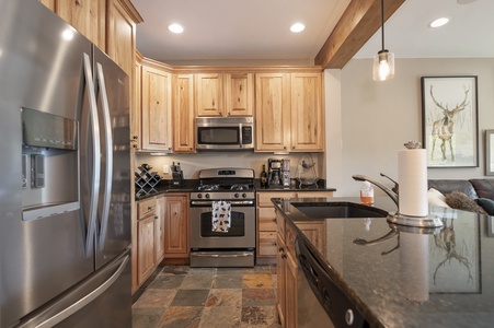 A modern kitchen with granite countertops and stocked with all your needs