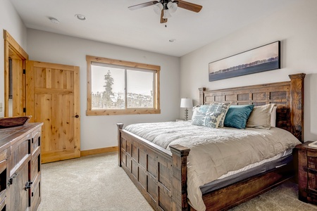 - Rustic bedroom with wooden frame king bed and window views   - Plush bedding for restful mountain vacation nights   - Comfortable retreat in peaceful Colorado cabin rental