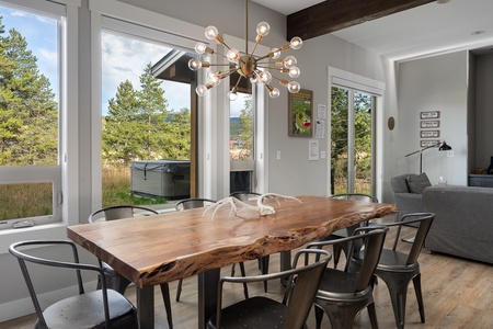 Elegant dining space with rustic wood table and modern chandelier   - Open concept design connects to kitchen for seamless entertaining   - Perfect Colorado vacation rental for family meals and gatherings