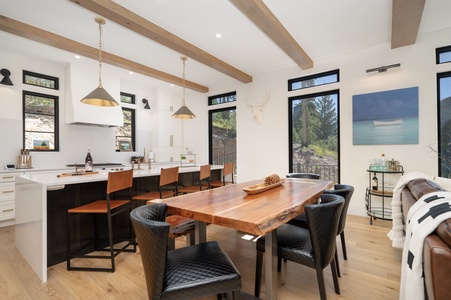 Modern kitchen with a wooden dining table, Luxurious decor and big windows bathe the space in natural light