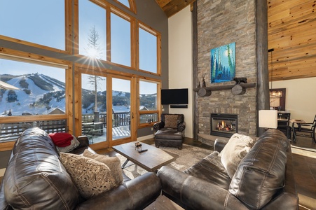 A cozy living room with large windows showcasing Winter Park Resort