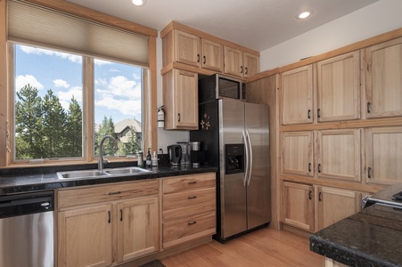 The bright fully stocked kitchen with windows letting in the natural light