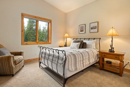 Bedroom with soft bedding and forest views through the window   - Peaceful retreat for restful nights in a mountain setting   - Warm lighting and inviting decor create a cozy sleep space