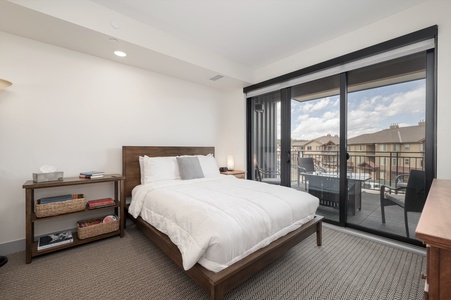 - Peaceful bedroom retreat with comfortable queen bed   - Sliding glass doors open to private balcony views   - Fresh linens and cozy bedding ensure restful sleep