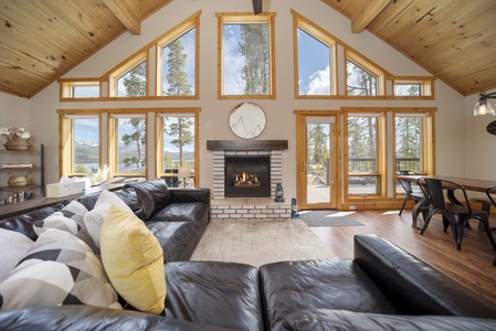 Large comfortable living area with a fireplace and loads of windows bathing the space in natural light