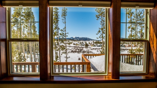 A luscious forested view outside the large windows overlooking the deck