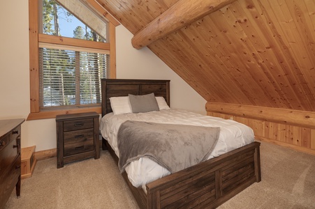 - Rustic bedroom with wood beam ceiling and soft lighting   - Queen bed with warm bedding for a peaceful night rest   - Scenic forest views from the window for cozy mornings