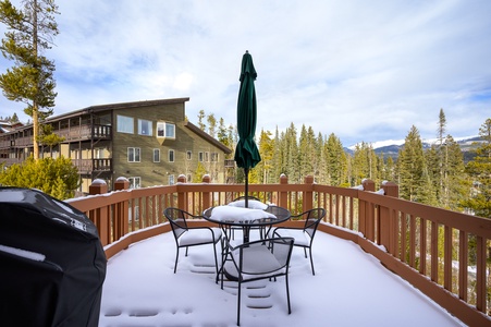 - Snow covered deck with mountain views creates a perfect outdoor retreat   - Patio table and chairs invite you to relax and take in the alpine setting   - Scenic forest surroundings enhance this peaceful winter getaway spot