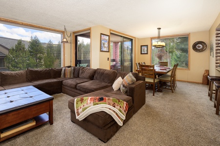 Open living area with cable TV and dining table for 8 with huge windows that bathe the space in natural light