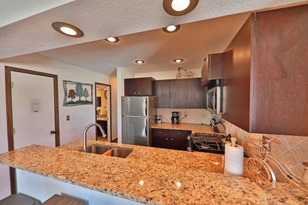 A modern kitchen with wood cabinets, stainless steel appliances, granite counter tops,