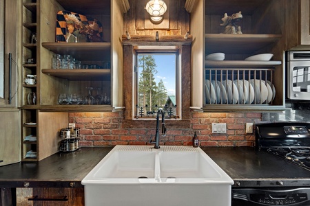 A kitchen view featuring a farmhouse double sink with a window