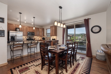 Wonderful dining table set for 6 next to large sliding glass doors leading to a lovely patio with outdoor seating