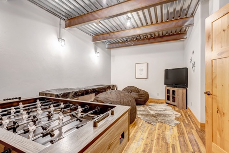 Game Room in Basement with foosball, video game console and shuffleboard