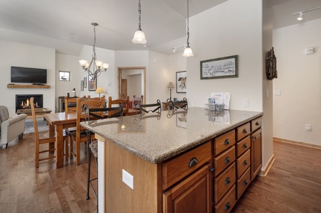 Open-concept kitchen and living area with granite counter tops and plenty of seating for your crew