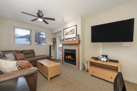 Cozy Living Room with pull out couch, gas fireplace, and ceiling fan