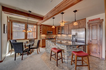 Modern kitchen with wooden cabinets, granite countertops, and a stone-clad island.