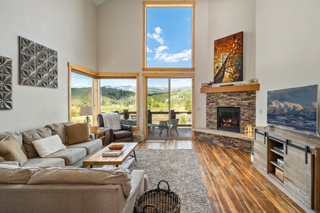 - Cozy living room with stone fireplace and tall windows   - Open mountain views create a bright inviting retreat   - Comfortable vacation rental perfect for family gatherings