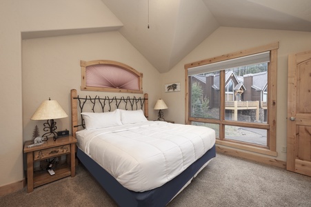 - Bright bedroom with king bed and tall vaulted ceiling design   - Large windows overlooking peaceful cabin scenery   - Perfect space for restful nights after mountain adventures
