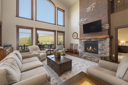 A cozy living room with large windows bathing the room with natural light and stunning views