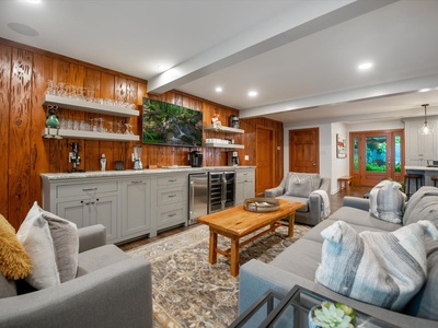 Gleesome Inn- Living room area with a mounted TV and lounge furniture