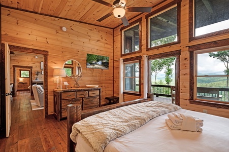 Feather & Fawn Lodge- Master bedroom with a dresser and mounted TV