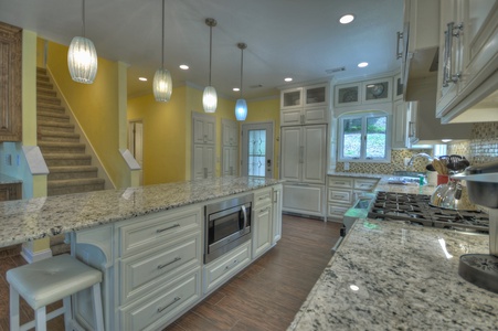 Jump Right In- Kitchen facing the island with cabinets and a microwave