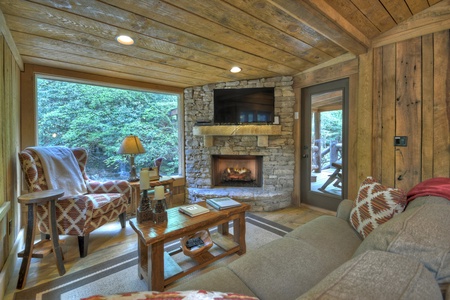 Hothouse Hideaway- Living area with a fireplace and TV