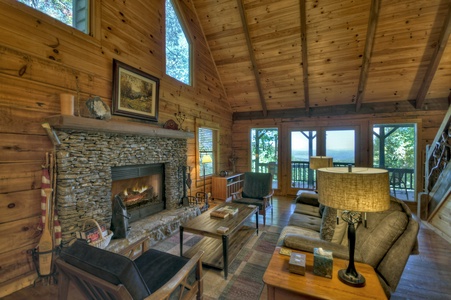 Ridgetop Pointaview- Entry level living room area with a stone fireplace and deck access