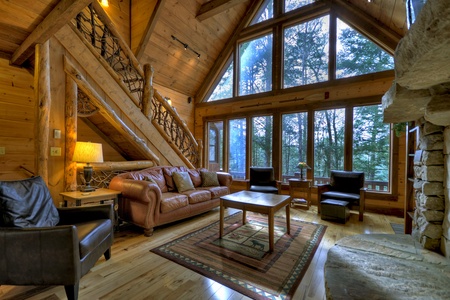 Reel Creek Lodge- Living room area with forest views and upstairs access
