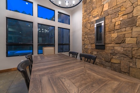 Cohutta Mountain Retreat- Dining room table with a stone accent wall