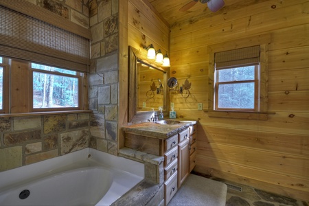 Reel Creek Lodge- Private bathroom with soaker tub view and vanity sink with a mirror