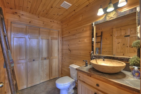 Grand Mountain Lodge- Entry level half bathroom with a toilet and sink