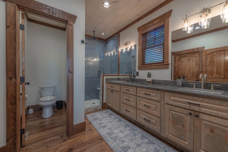 Southern Star- Full bathroom area with double vanity sink walk in shower and toilet