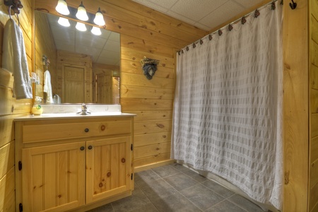 Grand Mountain Lodge- Lower level shared bathroom with a step up shower and sink