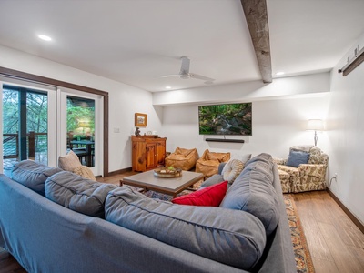 Gleesome Inn- Lower level living room area with couch, chairs and a TV