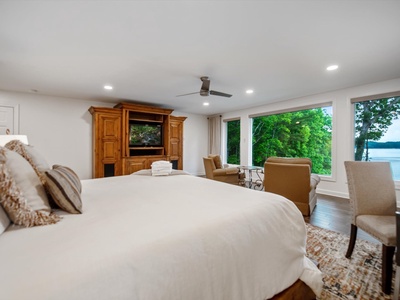 Gleesome Inn- Master bedroom with an entertainment center and TV overlooking the lake