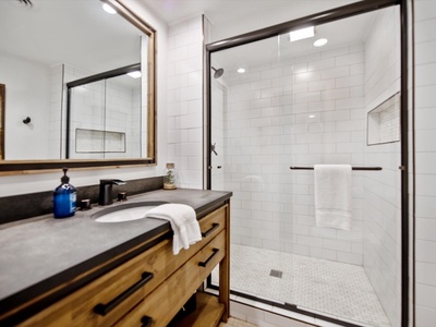 Gleesome Inn- Lower level bathroom with a walk in shower and vanity sink