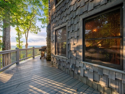 Aska Bliss- The deck with mountain views and rustic cabin exterior