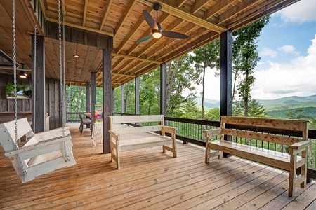 Feather & Fawn Lodge- Lower level deck fireplace with a swing