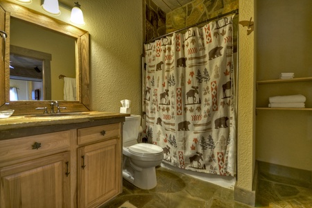 Reel Creek Lodge- Lower level bathroom with a step in tub, toilet and vanity sink