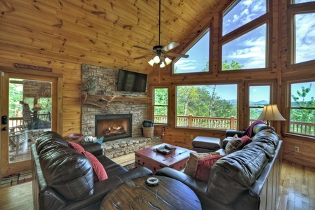 Aska Lodge- Fireplace with a mounted TV and deck access
