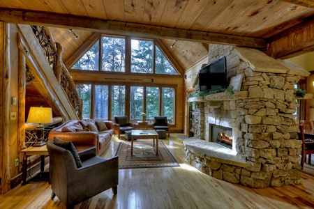 Reel Creek Lodge-  Entry level living room area with a stone fireplace