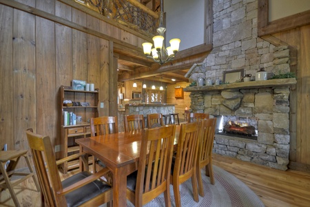 Reel Creek Lodge- Dining room area with table and chairs and a stone fireplace