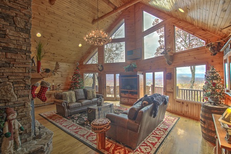 Grand Mountain Lodge- Living room area with couch seating mountain views, and a TV