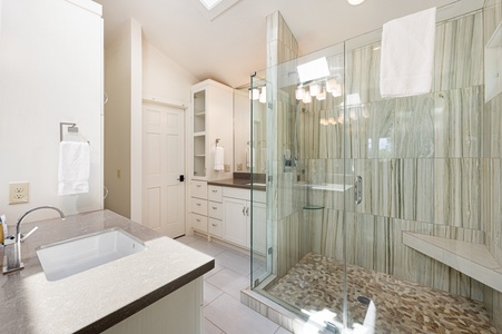 Kricket's Overlook- upper level master bathroom with a walk in shower and vanity sinks