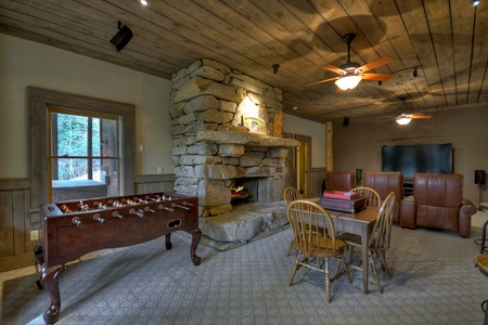 Reel Creek Lodge- Lower level game room with a stone fireplace