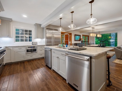 Gleesome Inn- Kitchen area with full appliances and white cabinet decor