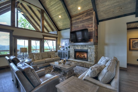 New Heights- Living area with a fireplace and deck access doors